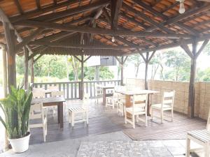 a patio with tables and chairs under a wooden roof at Hotel Salto do Norte in Blumenau