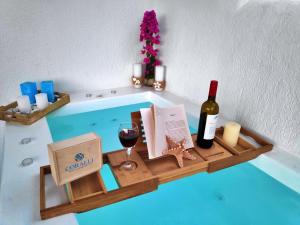 bandeja con una botella de vino y una copa de vino en Coralli Beach Apartments en Mikri Vigla
