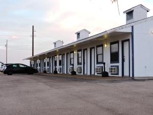 a white building with a car parked in front of it at Riata Inn - Marfa in Marfa
