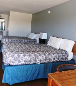 Riata Inn - Marfa في مارفا: غرفة الفندق بسرير وطاولة