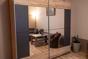 einen Spiegel im Wohnzimmer mit einem Tisch in der Unterkunft Studio Złotnicza in Jelenia Góra