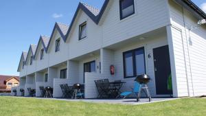 a building with chairs and tables in front of it at Domek Ga-Ba in Sarbinowo +8 photos