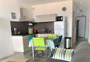 een keuken met een tafel en stoelen en een koelkast bij Appartement vue mer panoramique près de Porticcio in Pietrosella