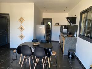 a kitchen with a table and chairs in a room at Gîte Le Moringa in Saint-Pierre