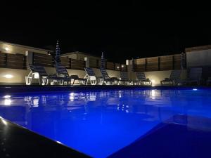 a group of chairs sitting next to a swimming pool at night at Gîte Le Moringa in Saint-Pierre