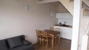 a kitchen and dining room with a table and a couch at Domek Ga-Ba in Sarbinowo