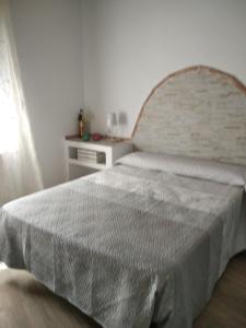 1 dormitorio con 1 cama grande con colcha blanca en Casa Rural Los Nietos, en Villaverde de Guadalimar