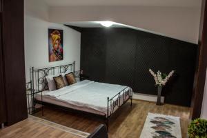 1 dormitorio con cama y pared negra en Happy Accomodation en Bucarest