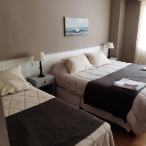 a hotel room with two beds and a couch at Casa Garay 602 in Mar del Plata +22 photos