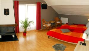 ディナンにあるオーベルジュ グリル ル フレイのベッドルーム1室(赤とオレンジのベッド1台、テーブル付)