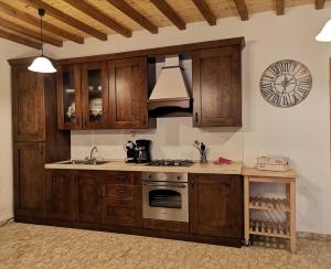 a kitchen with wooden cabinets and a clock on the wall at Il Castello di Monteggiori in Camaiore