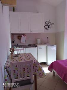 a small kitchen with a table and a refrigerator at Apartman Snježana in Fažana