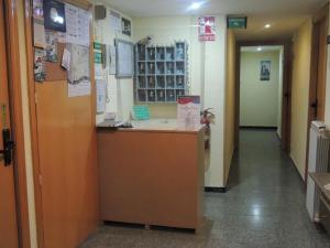 a hospital hallway with a reception desk and a hallway sidx sidx at Hostal Cumbre in Zaragoza