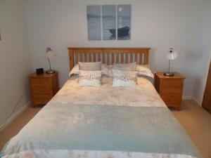 a bedroom with a large bed with two night stands at Seapinks Cottage in Portland