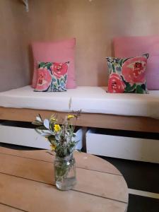 2 camas en una habitación con una mesa y un jarrón de flores en Las Luciernagas Posada de Mar, en La Pedrera
