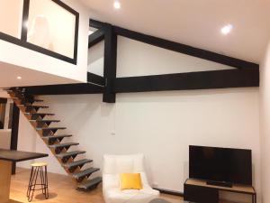 sala de estar con escalera de caracol y TV en " Les Lofts de Mérigonde " en Castres