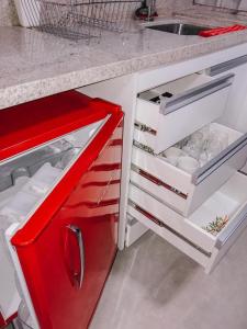 a kitchen with a red and white refrigerator with its door open at Apart Hotel com Piscina, centro de Brasilia in Brasilia