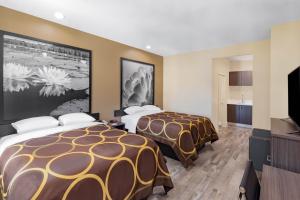 a hotel room with two beds and a flat screen tv at Super 8 by Wyndham Houston NW Beltway 8-West Rd in Houston