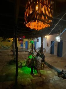 a group of people sitting at a table at night at Pousada e Restaurante Tremembé in Icapuí