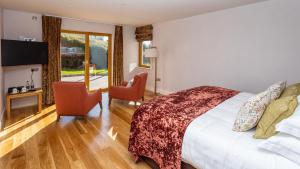 a hotel room with a bed and two chairs at Inch Beach House B&B in Inch