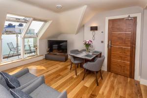 a living room with a table and chairs and a television at Inch Beach House B&B in Inch