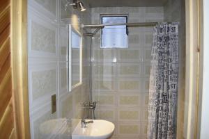 baño con lavabo y cortina de ducha en Cabañas y Tinajas Borde río, en Licán Ray
