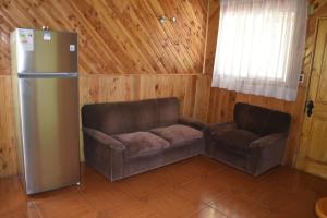 a living room with a couch and a refrigerator at Cabañas y Tinajas Borde río in Licán Ray