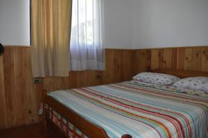 a bed with two pillows on it in a bedroom at Cabañas y Tinajas Borde río in Licán Ray
