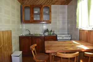 cocina con mesa de madera y fregadero en Cabañas y Tinajas Borde río, en Licán Ray