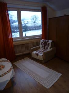 a living room with a chair and a window at Ubytovanie u Tomku in Rejdová