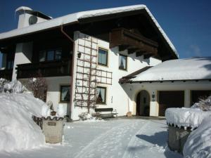 ein Haus mit Schnee auf dem Boden davor in der Unterkunft Haus Scheucher - Chiemgau Karte in Inzell