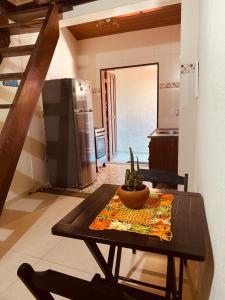 uma mesa num quarto com uma cozinha com uma mesa sidx sidx em Mandacaru Chalés e Suítes Itamambuca em Ubatuba