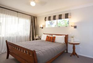 a bedroom with a large bed and a window at Pacific Palms Resort in Papamoa