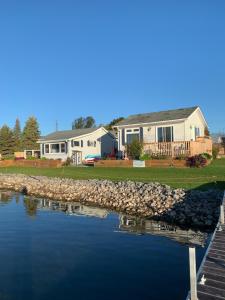 a house with a dock next to a body of water at The Birch in Wellington