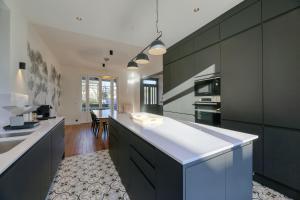 a kitchen with black cabinets and a white counter top at Villa Berry Centre Deauville - Chic & Stylée - Plage à 4 min in Deauville