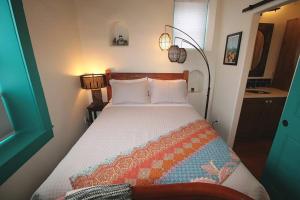 a small bedroom with a bed with a bedspread at Closson Studio - Stylish - Near Plaza - Queen bed in Santa Fe