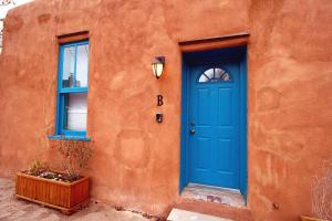 a blue door on the side of a orange building at Closson Studio - Stylish - Near Plaza - Queen bed in Santa Fe