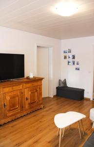 una sala de estar con TV de pantalla plana en un armario de madera en Ferienwohnung Bergoase, en Fischen
