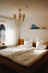 a bedroom with a bed with white sheets and a window at Ferienwohnung Bergoase in Fischen