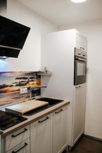 a kitchen with white cabinets and a stove top oven at Ferienwohnung Bergoase in Fischen