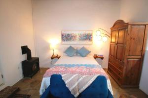 een slaapkamer met een groot bed en een blauwe stoel bij Closson Getaway - Courtyard - Railyard and Plaza in Santa Fe