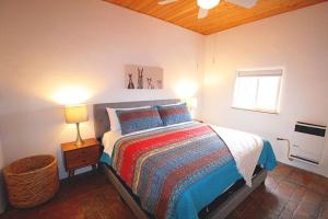 1 dormitorio con 1 cama con lámpara y ventana en Closson Casita - Patio & Fire Pit - Near Plaza - 1BR, en Santa Fe