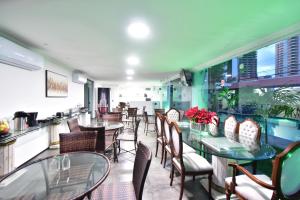 un restaurante con mesas, sillas y una barra en LIVE IN FORTALEZA HOTEL, en Fortaleza