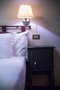 a bed with a lamp and a nightstand next to a bed at Bastimento in Fiorenzuola dʼArda