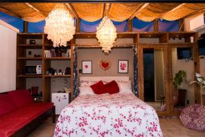 a bedroom with a bed with red pillows and chandeliers at Mansion Aline in Rio de Janeiro