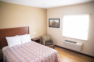 1 dormitorio con cama, ventana y silla en White House Suites, en Plainfield