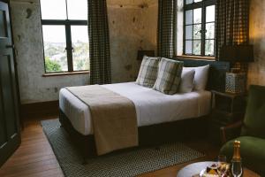 um quarto com uma cama com lençóis brancos e almofadas em The Convent Hotel em Auckland