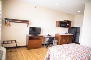 a hotel room with a bed and a desk with a computer at White House Suites in Plainfield