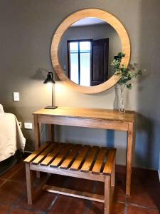 a wooden table with a mirror and a wooden bench at El Arribo Hotel in San Salvador de Jujuy