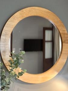 a mirror with a wooden frame and a plant at El Arribo Hotel in San Salvador de Jujuy